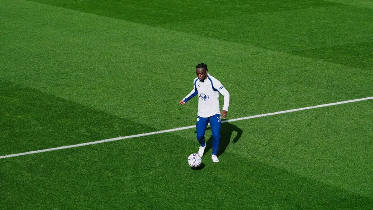 Jérémy Doku conduz a bola durante o treino do Manchester City.