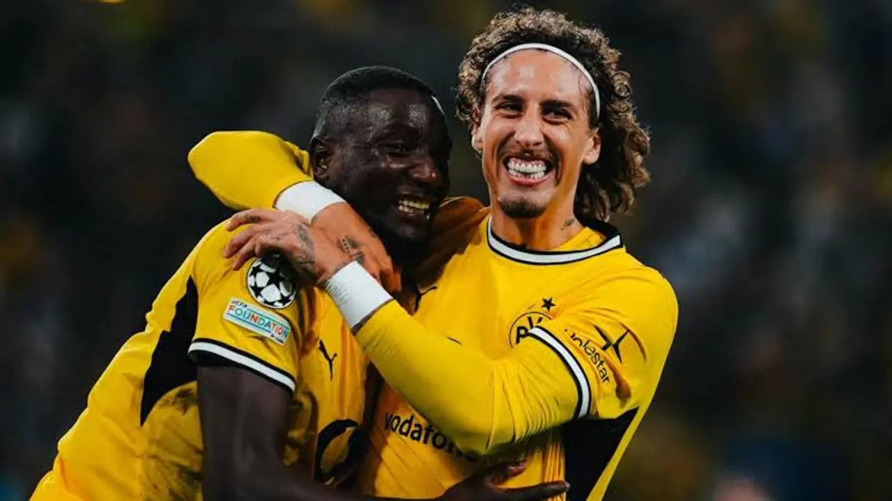 Jogadores do Borussia Dortmund comemoram abraçados em campo.